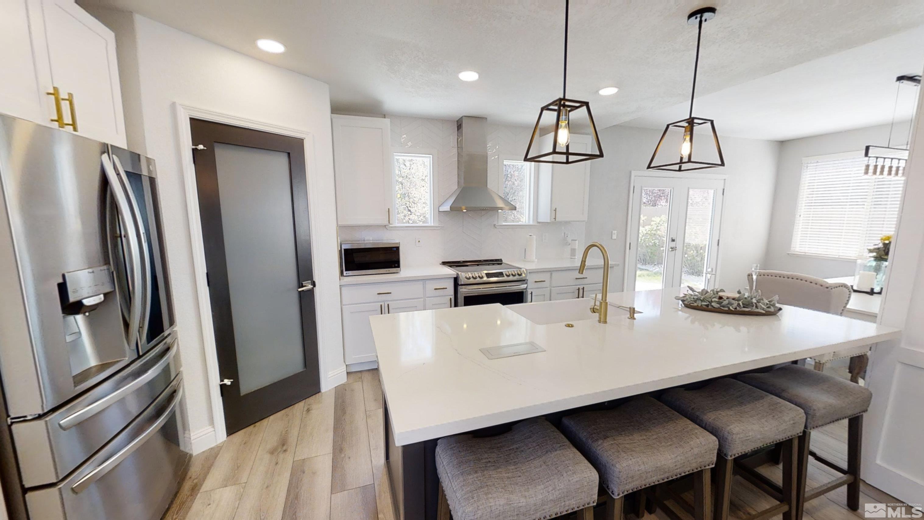 10018 Silver Star Drive Reno, NV 89521 - Photo 8 of 38 a kitchen with stainless steel appliances granite countertop a sink a refrigerator a stove a dining table and chairs