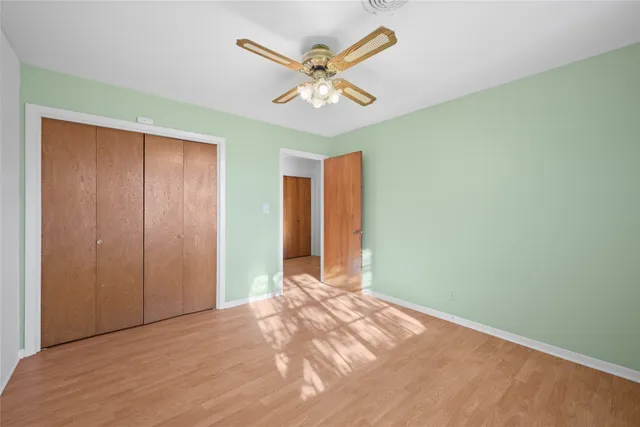 an empty room with closet and fan