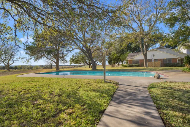 a view of swimming pool with tree and yard