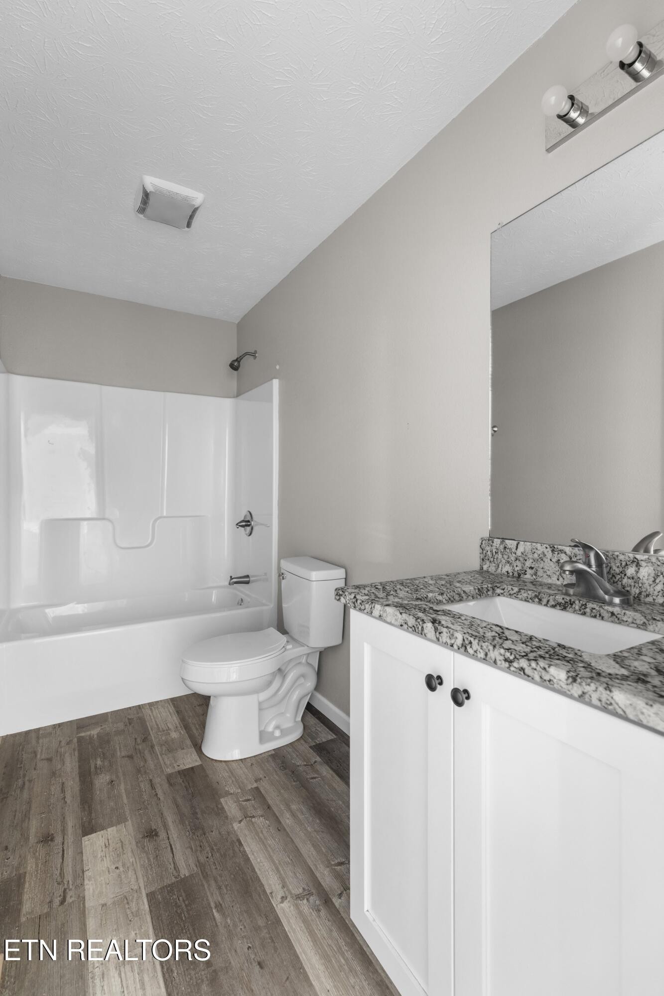 1159 Camellia Road Newport, TN 37821 - Photo 42 of 45 a bathroom with a granite countertop toilet a sink and a bathtub
