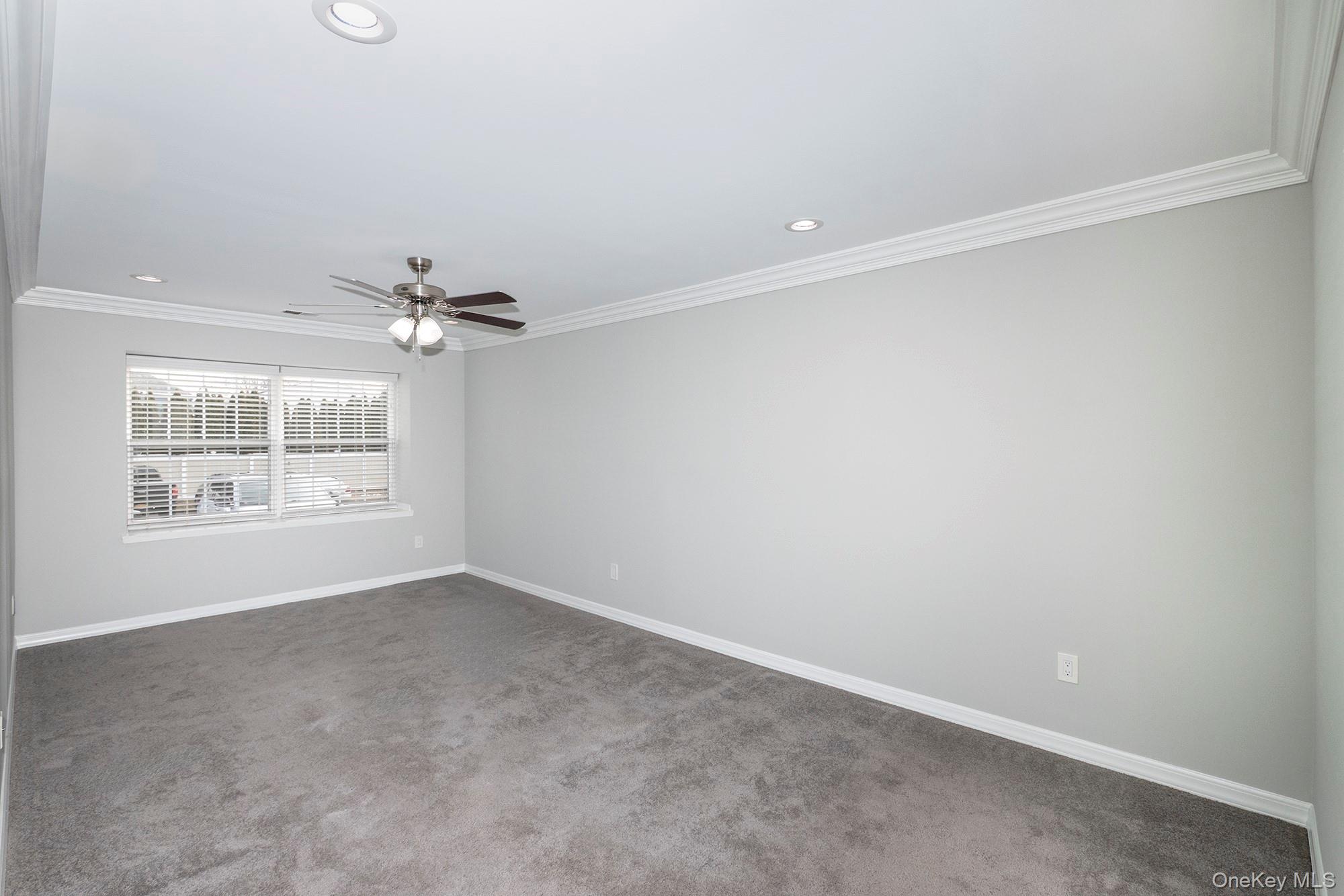 425 Newbridge Road, Unit 37 East Meadow, NY 11554 - Photo 3 of 8 an empty room with windows and fan