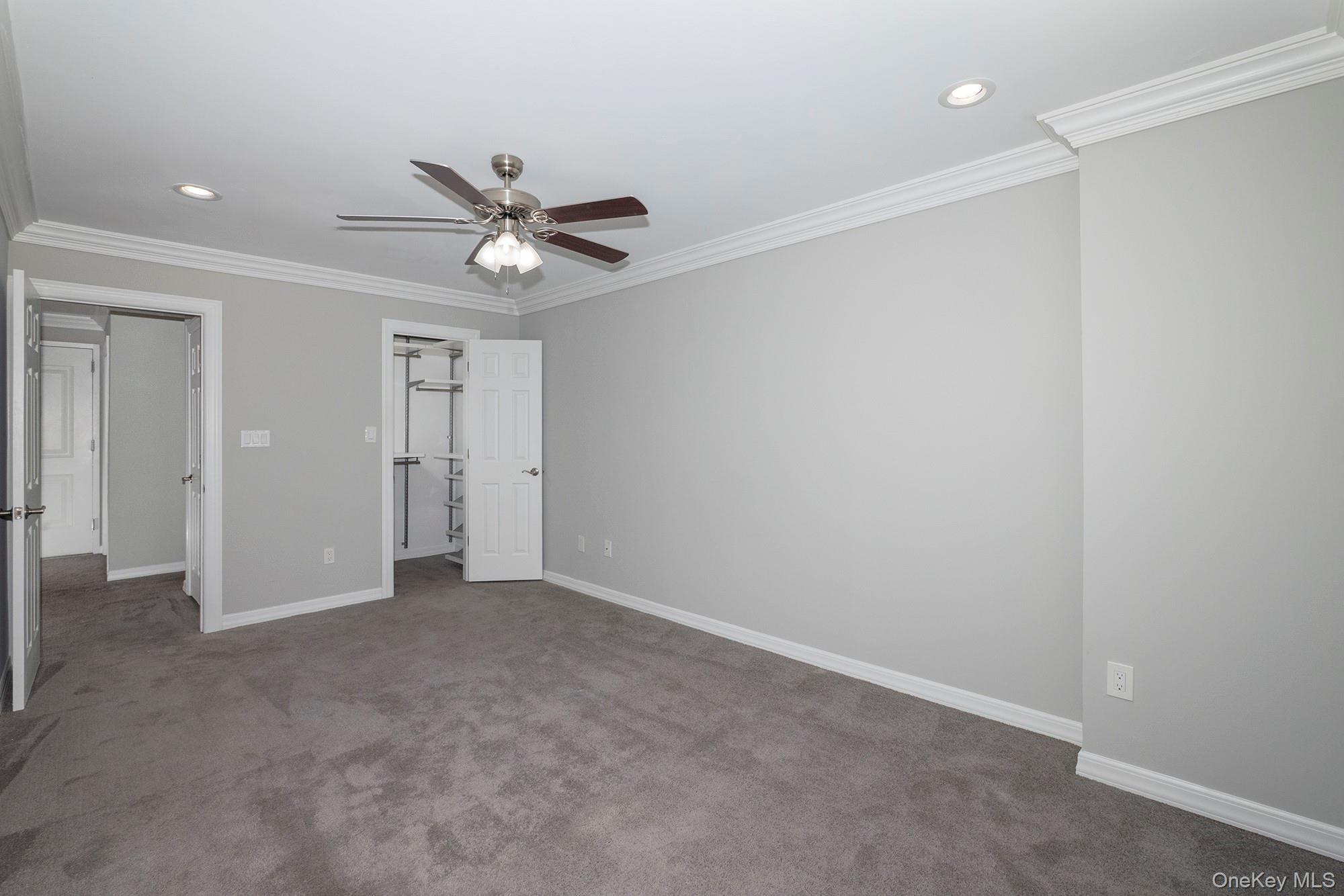 425 Newbridge Road, Unit 37 East Meadow, NY 11554 - Photo 6 of 8 an empty room with closet and a ceiling fan