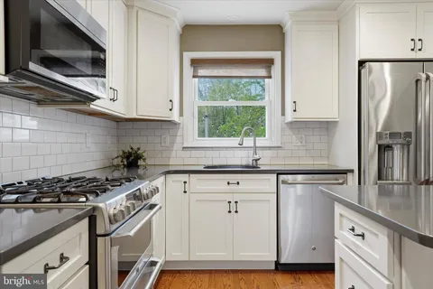 a kitchen with stainless steel appliances a sink stove and microwave
