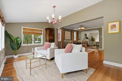 a living room with furniture a chandelier and a large window