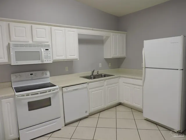 a kitchen with white cabinets and white appliances