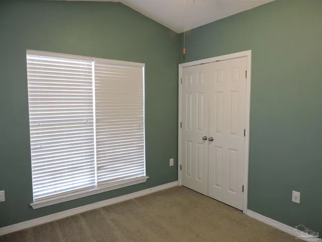 an empty room with a window and a ceiling fan
