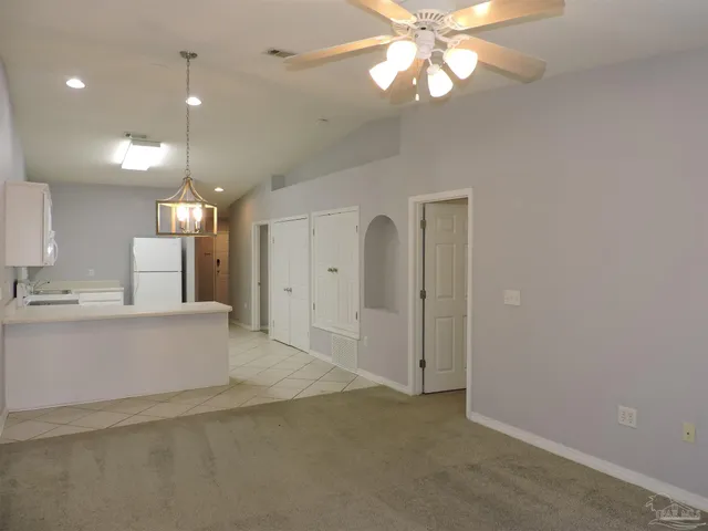 a view of kitchen with granite countertop cabinets and refrigerator