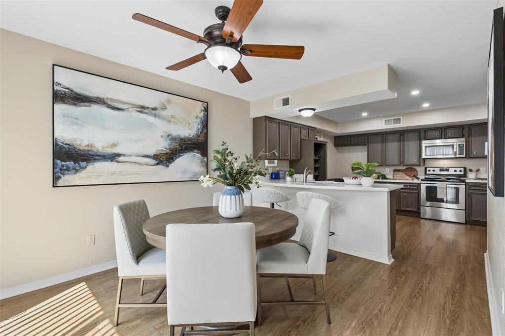 4962 Thunder Road Dallas, TX 75244 - Photo 2 of 26 Dining area with wood-finish flooring featuring a wood-tone ceiling fan and sliding glass doors to the patio.
