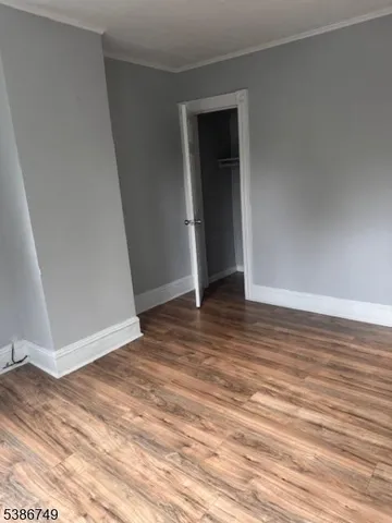 an empty room with wooden floor and closet