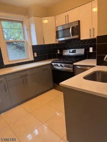 a kitchen with stainless steel appliances a stove a sink and a microwave