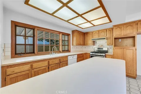 a kitchen with stainless steel appliances granite countertop a refrigerator and wooden cabinets