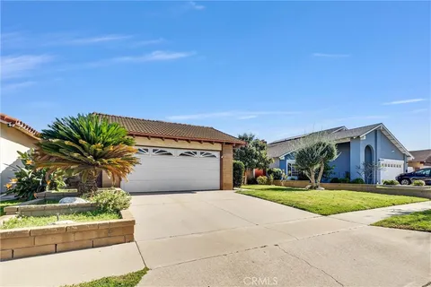 a front view of a house with a yard and potted plants