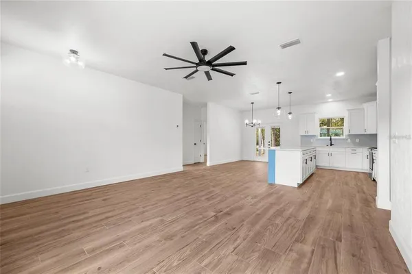 a view of a kitchen with a sink and dishwasher a refrigerator with wooden floor