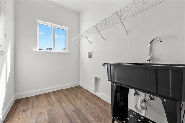 a kitchen with a sink a microwave and wooden floor