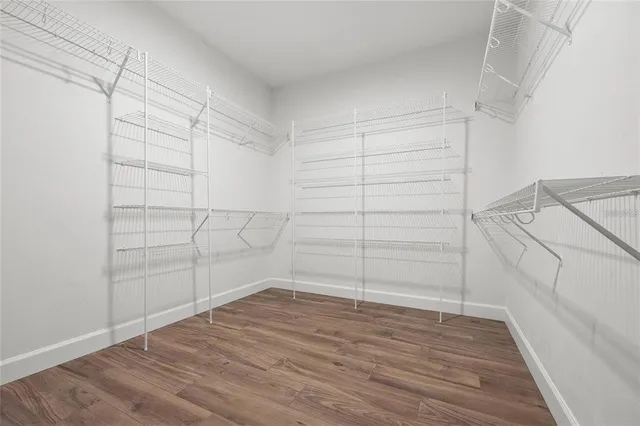 a view of walk in closet with empty racks