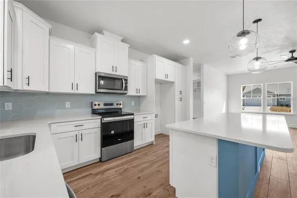 a kitchen with granite countertop white cabinets and white appliances