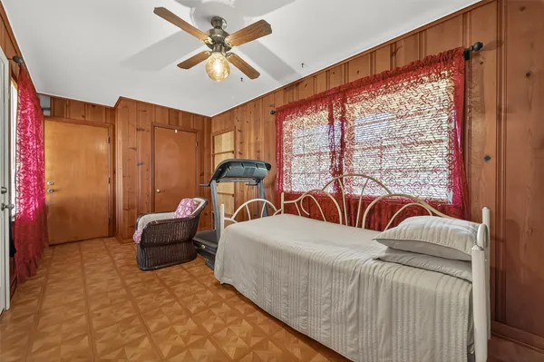 a living room with furniture a ceiling fan and a large window