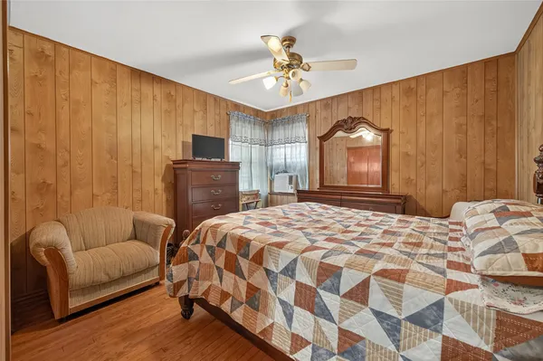 a bedroom with a bed couch and chandelier