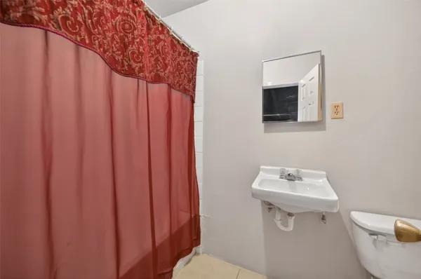 a bathroom with a sink a toilet and a mirror