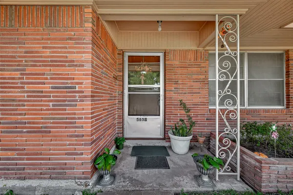 a front view of a house with a potted plant