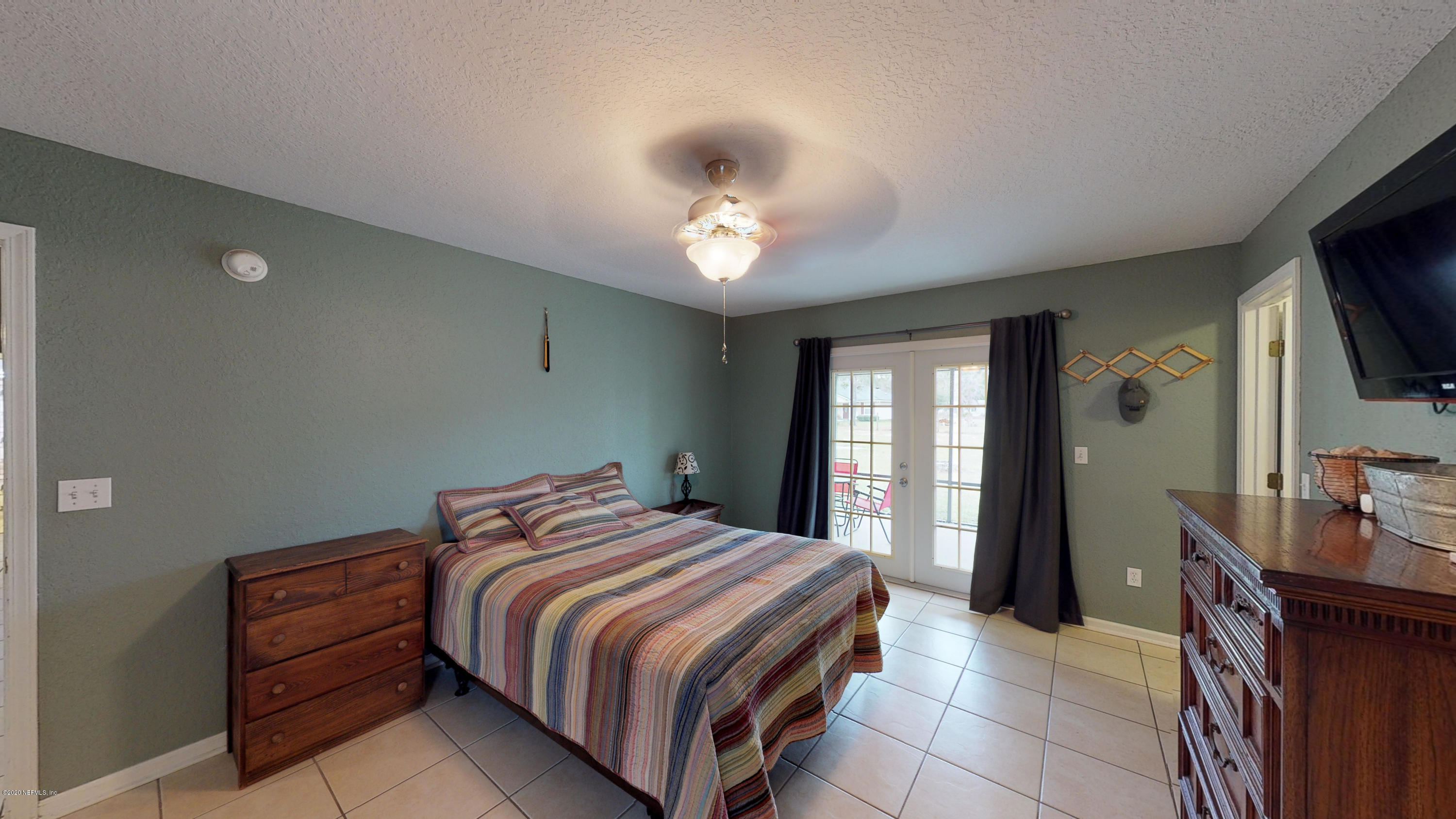 3990 Bronco Road Middleburg, FL 32068 - Photo 17 of 40 a bedroom with a bed and a flat screen tv
