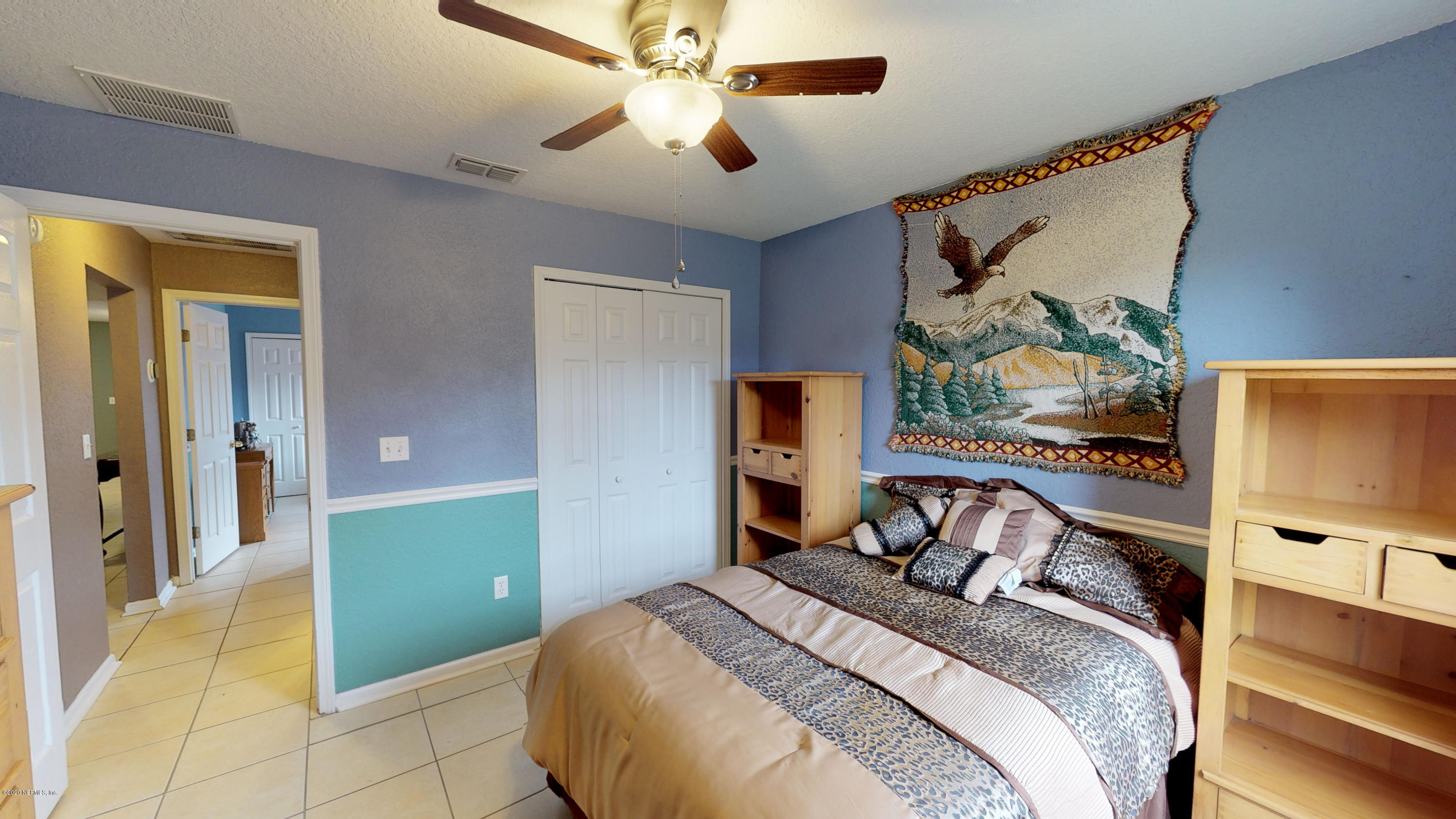3990 Bronco Road Middleburg, FL 32068 - Photo 23 of 40 a bedroom with a bed and a chandelier