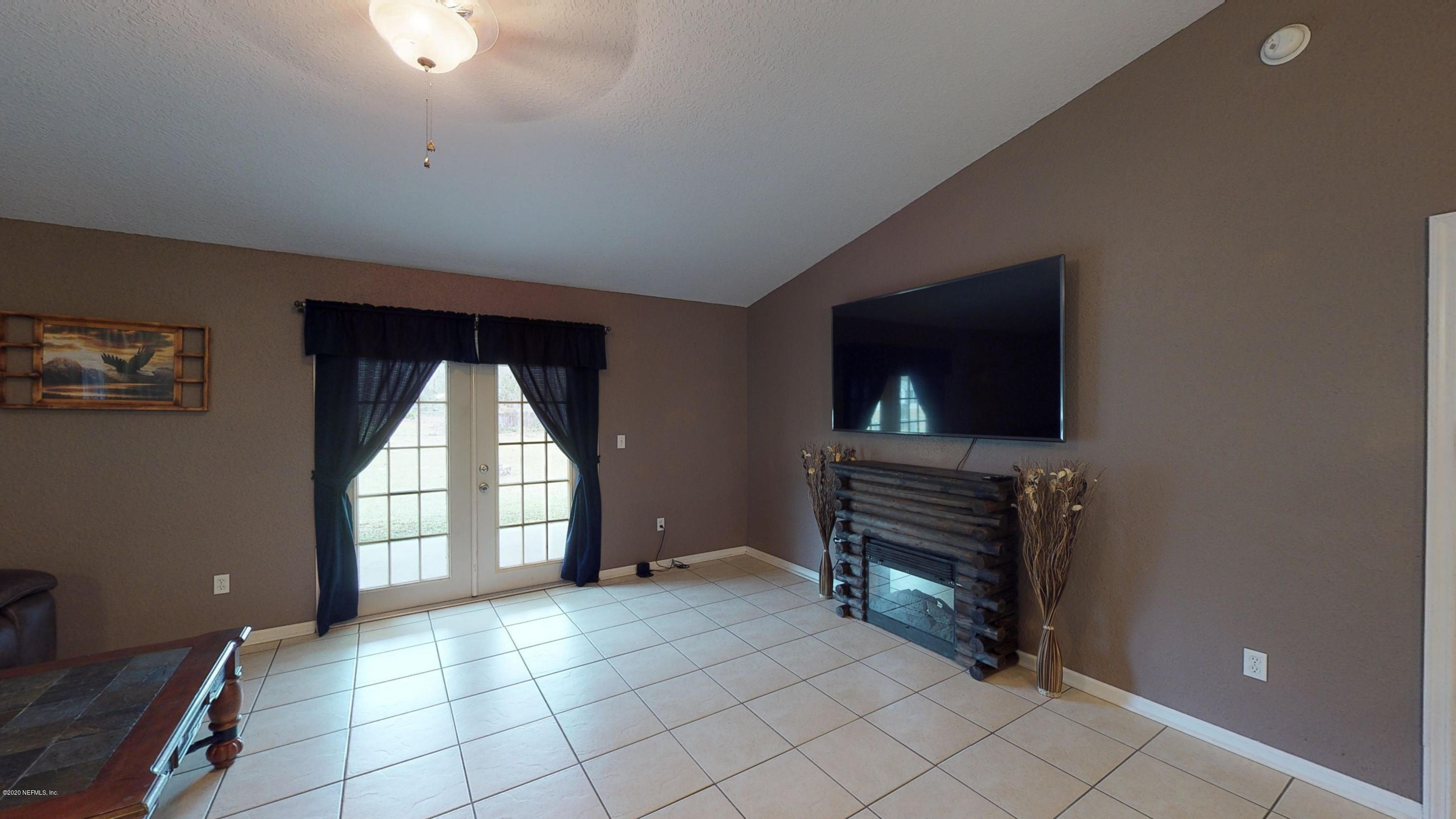 3990 Bronco Road Middleburg, FL 32068 - Photo 3 of 40 a view of an empty room with a fireplace and a window