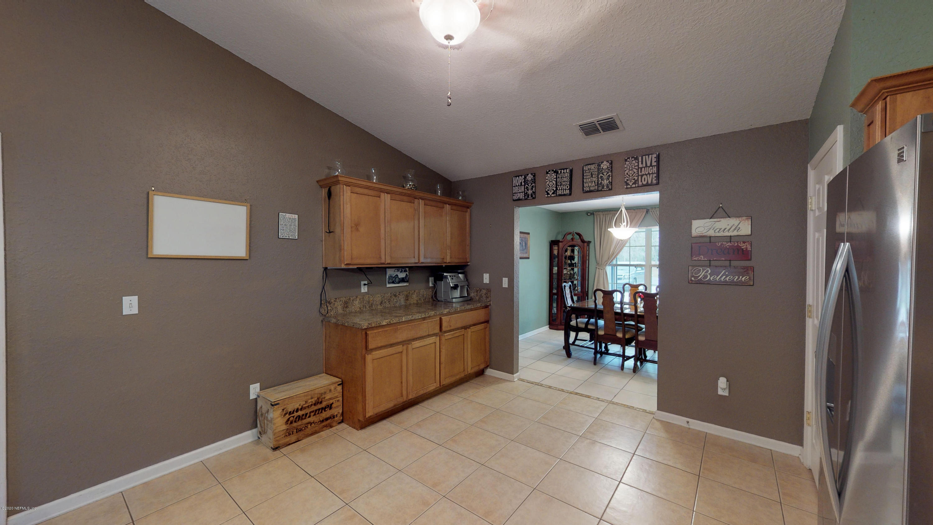 3990 Bronco Road Middleburg, FL 32068 - Photo 8 of 40 a room with furniture a flat screen tv and a refrigerator
