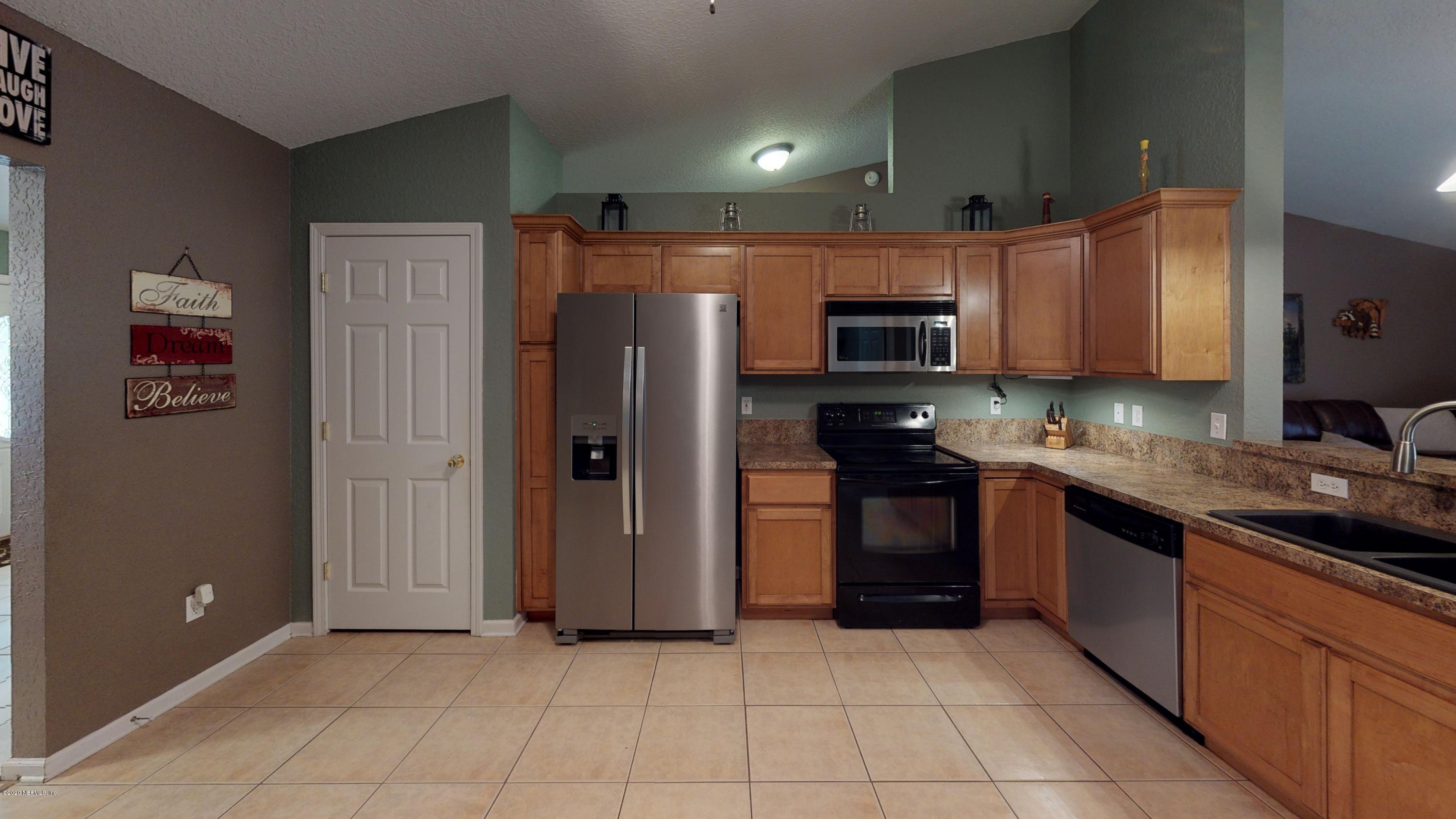 3990 Bronco Road Middleburg, FL 32068 - Photo 9 of 40 a kitchen with stainless steel appliances granite countertop a refrigerator and a stove top oven
