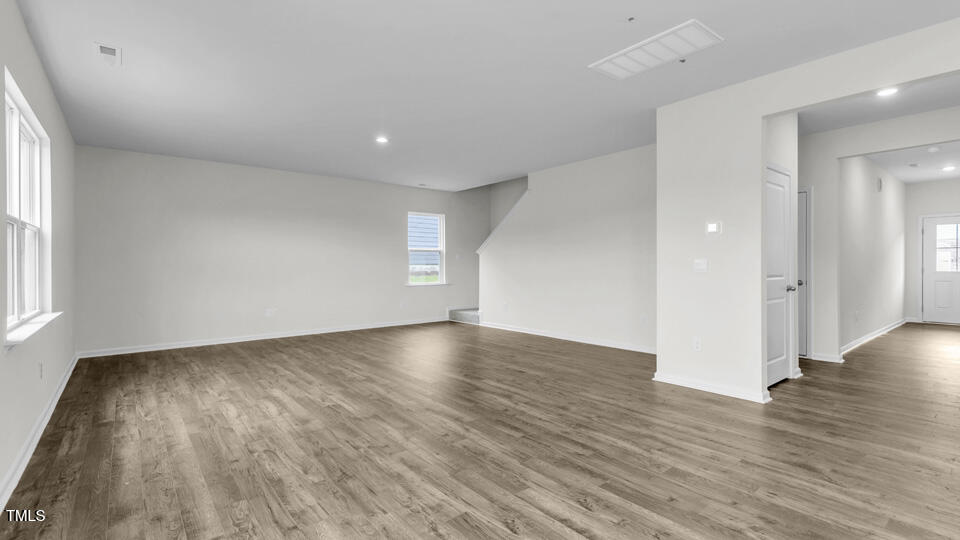 812 Comice Pear Way Willow Spring, NC 27592 - Photo 11 of 42 an empty room with wooden floor and windows