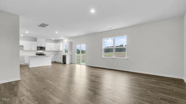 a view of kitchen with stove and wooden cabinets