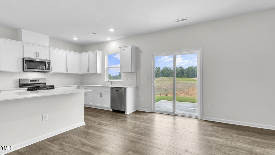 812 Comice Pear Way Willow Spring, NC 27592 - Photo 10 of 42 a kitchen with a stove a sink and a microwave