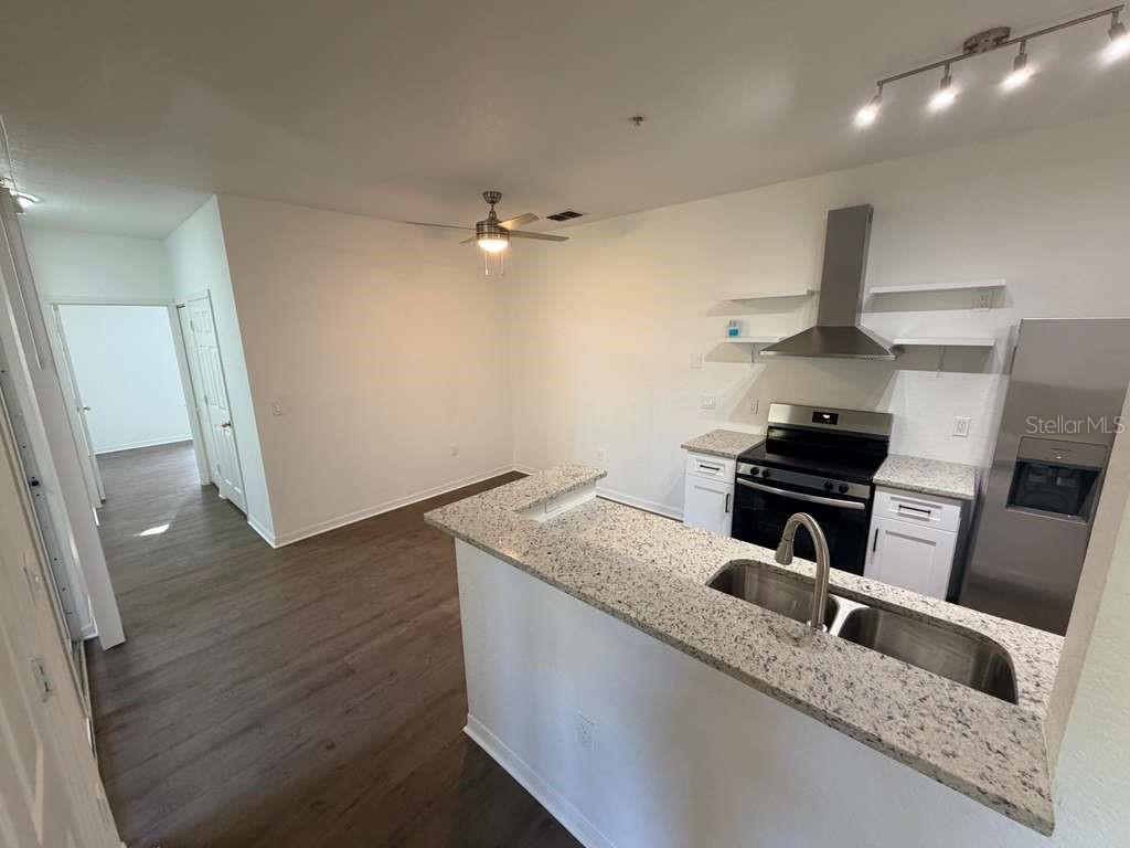 825 Grand Regency Point, Unit 102 Altamonte Springs, FL 32714 - Photo 5 of 29 a kitchen with granite countertop a stove and a refrigerator