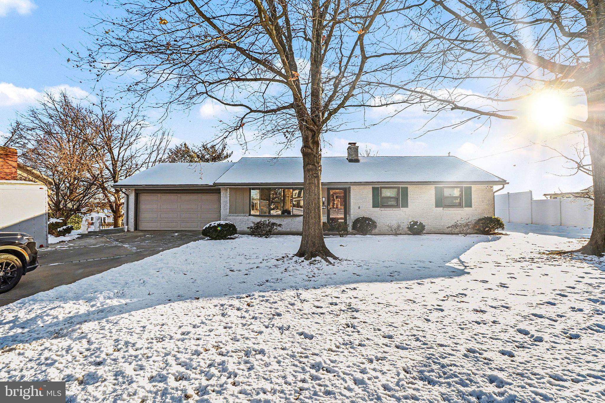 a front view of a house with a yard covered in snow