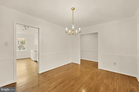 a view of a room with wooden floor and chandelier