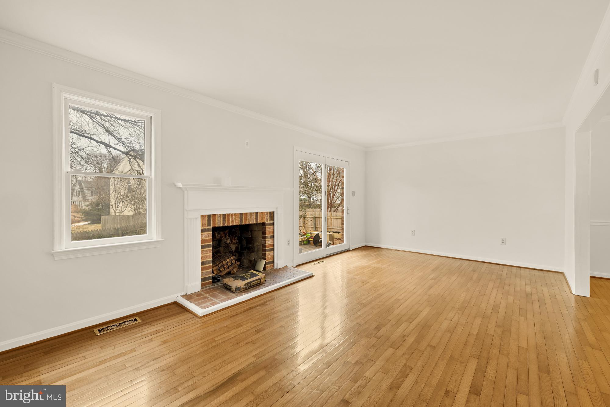 2 Spindrift Way Annapolis, MD 21403 - Photo 16 of 39 an empty room with windows a fireplace and wooden floor
