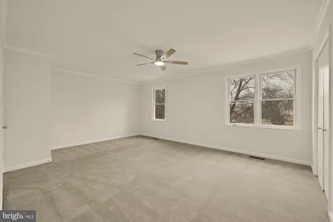 a view of an empty room with a ceiling fan