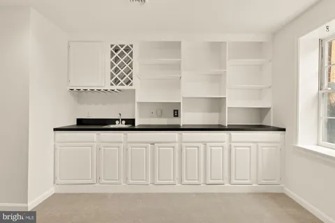 a kitchen with white cabinets and sink