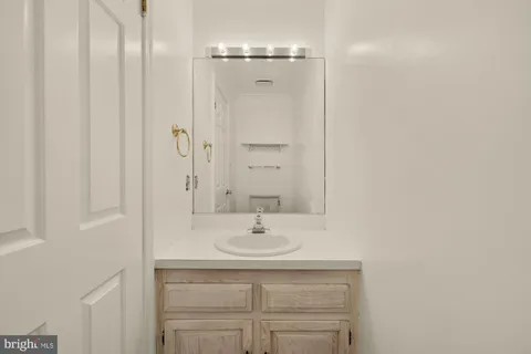 a bathroom with a sink a light fixture and a mirror