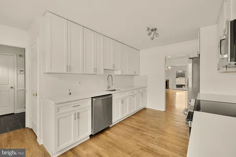 a large white kitchen with cabinets