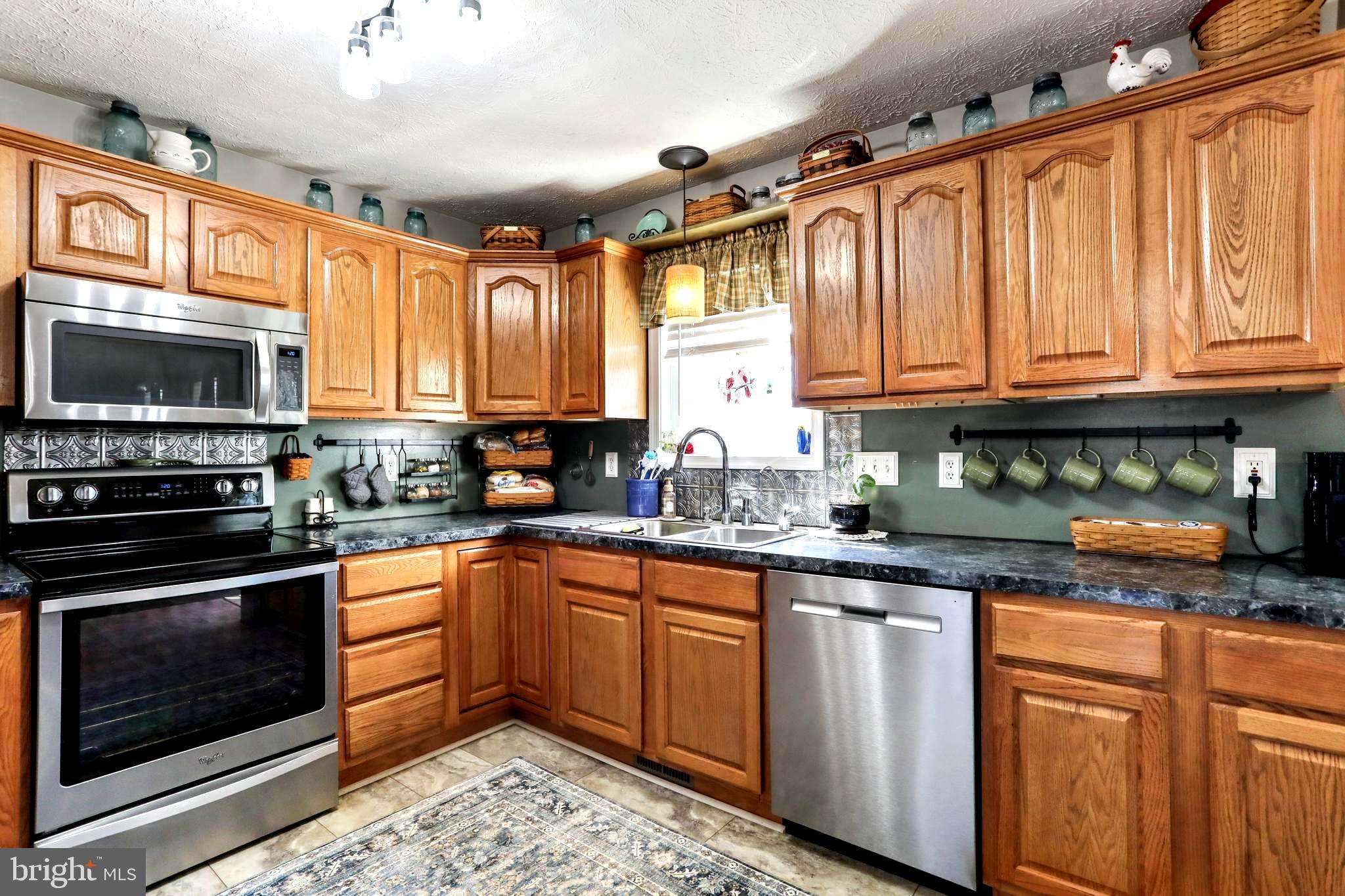 1147 Happy Ridge Drive Front Royal, VA 22630 - Photo 3 of 42 a kitchen with stainless steel appliances granite countertop a stove sink microwave and cabinets