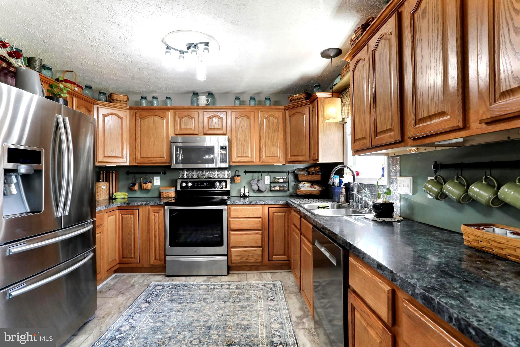 1147 Happy Ridge Drive Front Royal, VA 22630 - Photo 4 of 42 a kitchen with stainless steel appliances granite countertop a stove top oven a sink and dishwasher