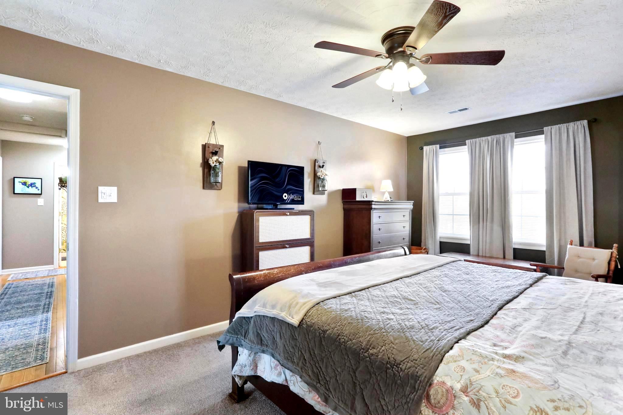 1147 Happy Ridge Drive Front Royal, VA 22630 - Photo 7 of 42 a bedroom with a large bed and a chandelier