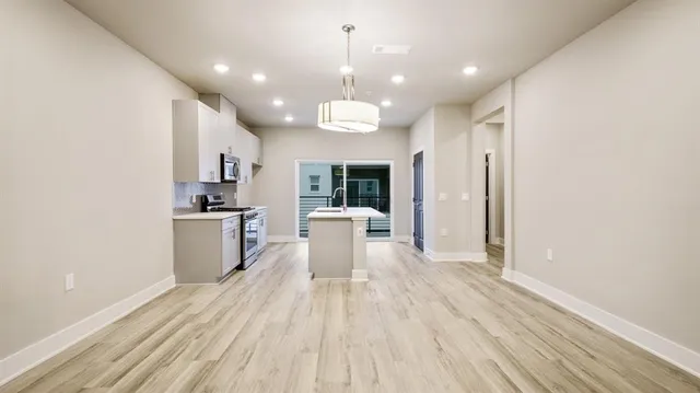 a open kitchen with white cabinets and stainless steel appliances