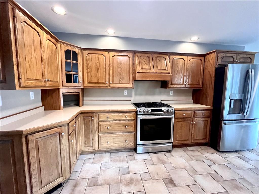 475 Bradys Ridge Road Beaver, PA 15009 - Photo 9 of 38 a kitchen with stainless steel appliances granite countertop a refrigerator a sink dishwasher a stove with wooden cabinets and floor