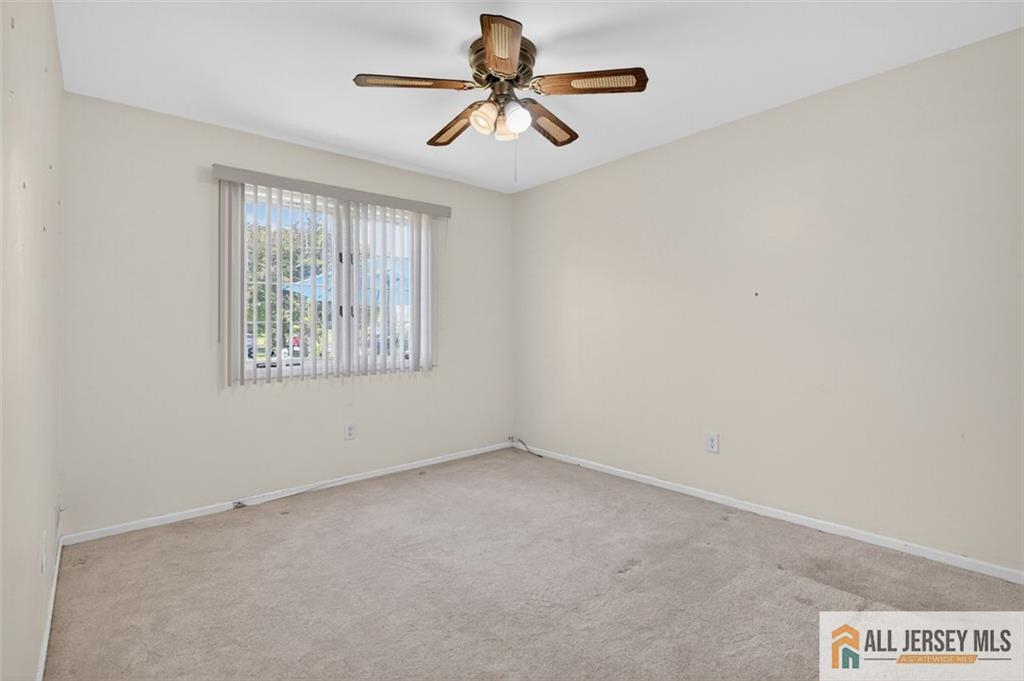40C Rutland Lane, Unit 40B Monroe Township, NJ 08831 - Photo 16 of 37 an empty room with windows and chandelier fan