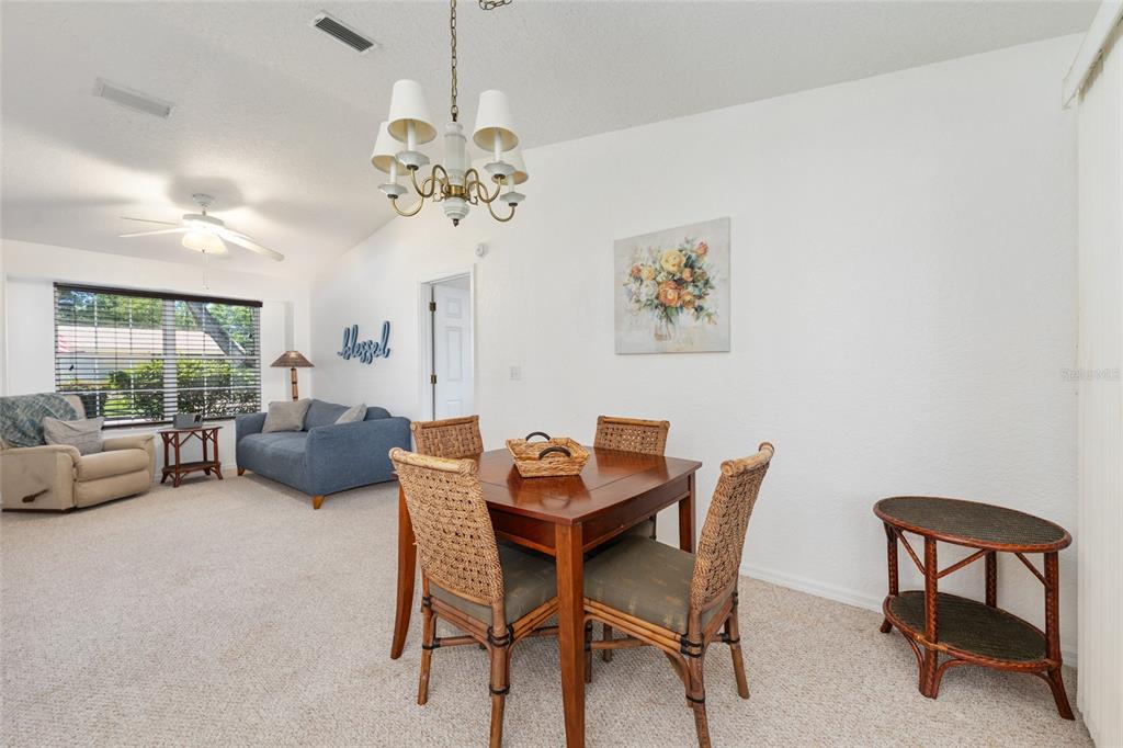 8038 Southwest 108th Loop Ocala, FL 34481 - Photo 10 of 48 a view of a dining room with furniture a chandelier and a window