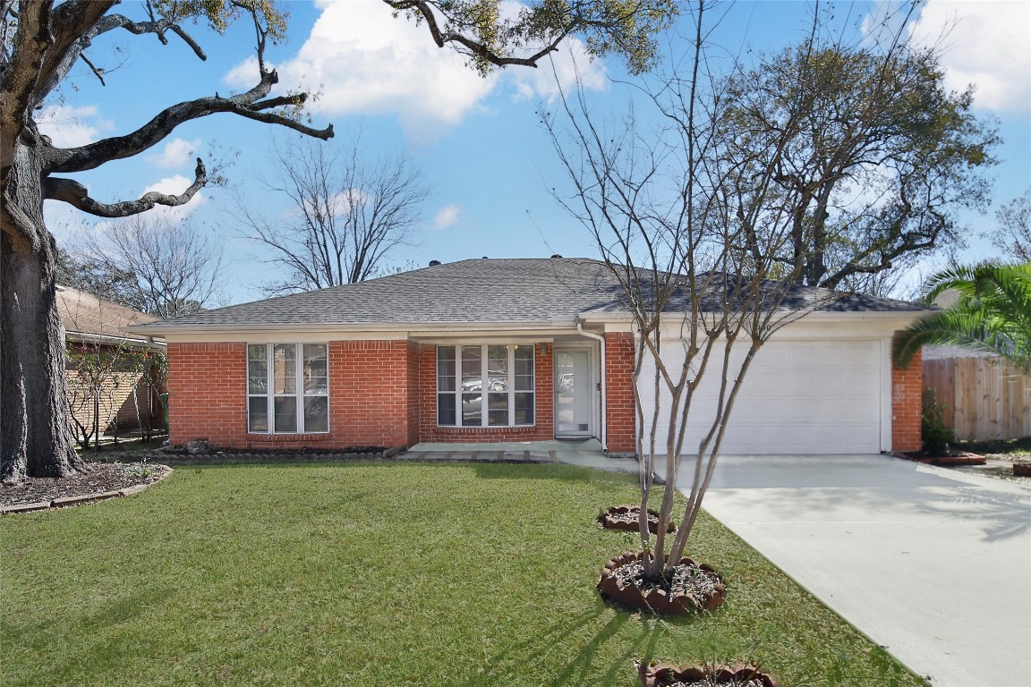 990 Redway Lane Houston, TX 77062 - Photo 1 of 21 a front view of a house with a garden and trees