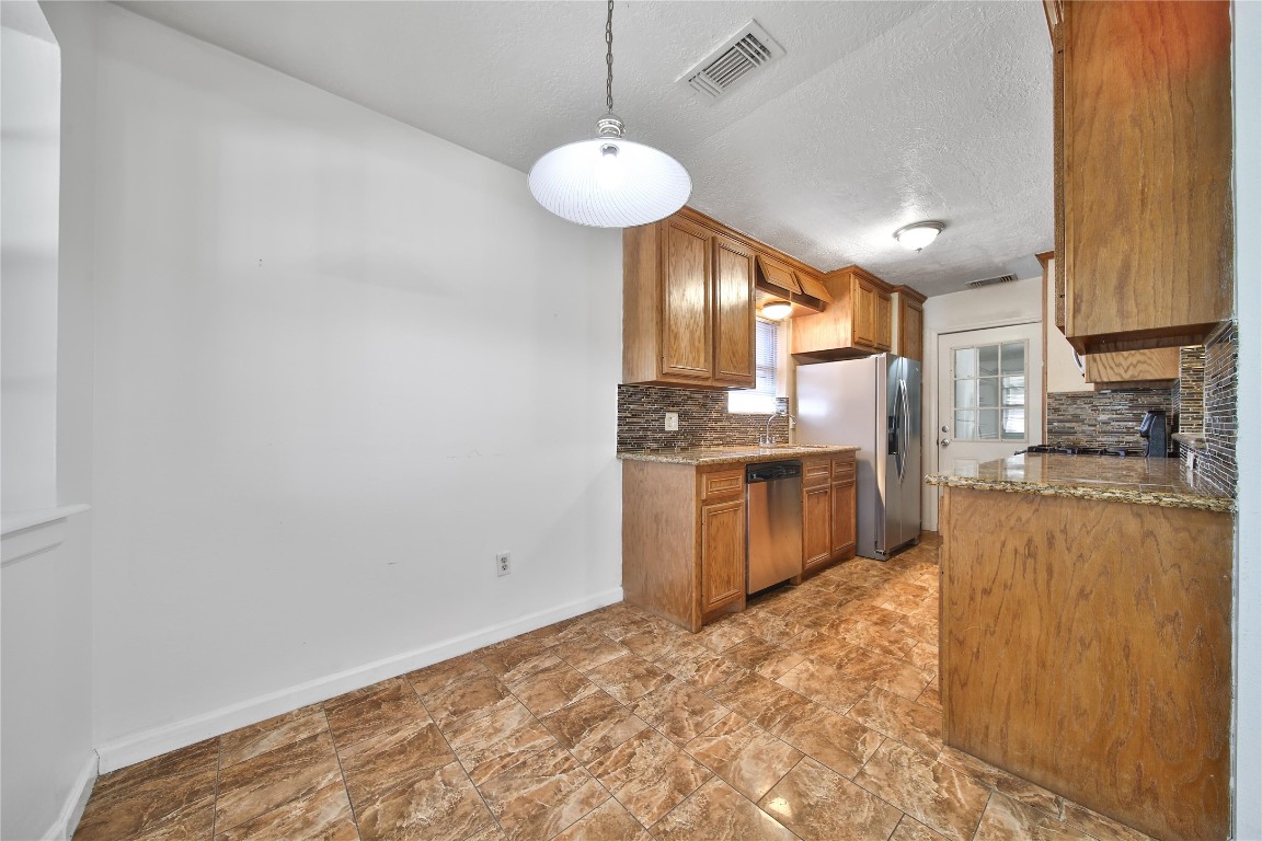 990 Redway Lane Houston, TX 77062 - Photo 9 of 21 a kitchen with stainless steel appliances granite countertop a sink a stove and a refrigerator