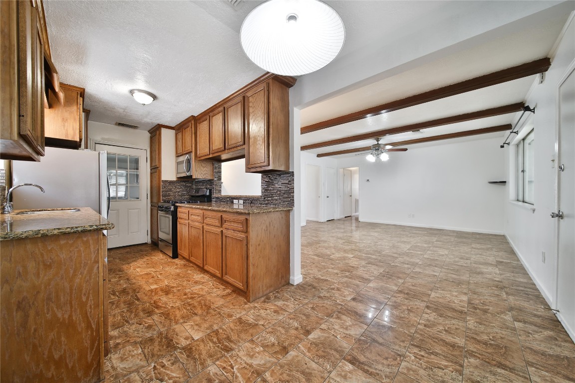 990 Redway Lane Houston, TX 77062 - Photo 10 of 21 a kitchen with granite countertop a stove refrigerator and cabinets